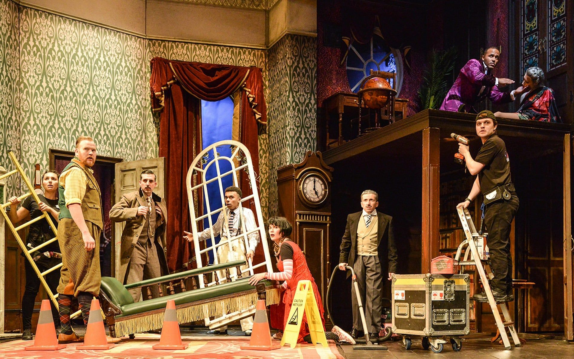 Cast members on stage during a chaotic scene from "The Play That Goes Wrong