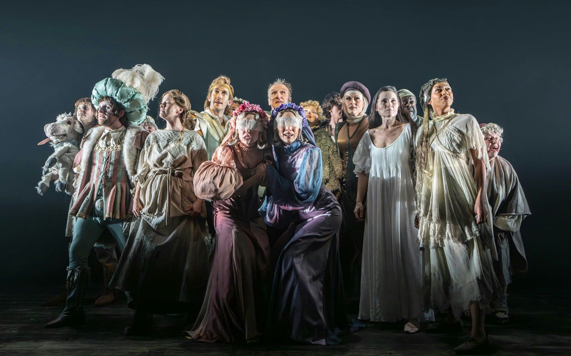 Cast of "Into The Woods" in costume on stage during a theatrical performance