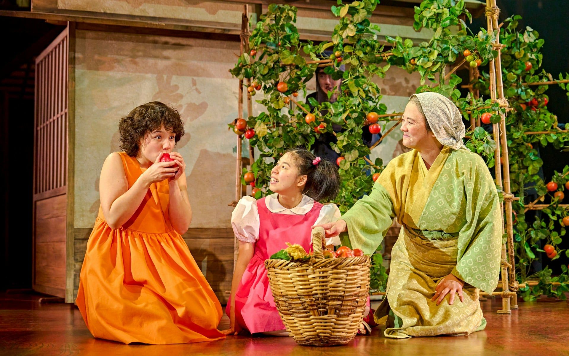 Three actors in colorful costumes on stage with a basket of fruit, My Neighbour Totoro production