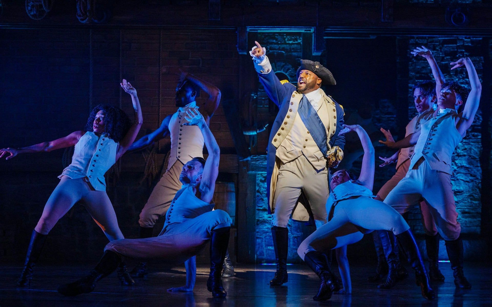 Cast performing a scene from the Hamilton musical on stage
