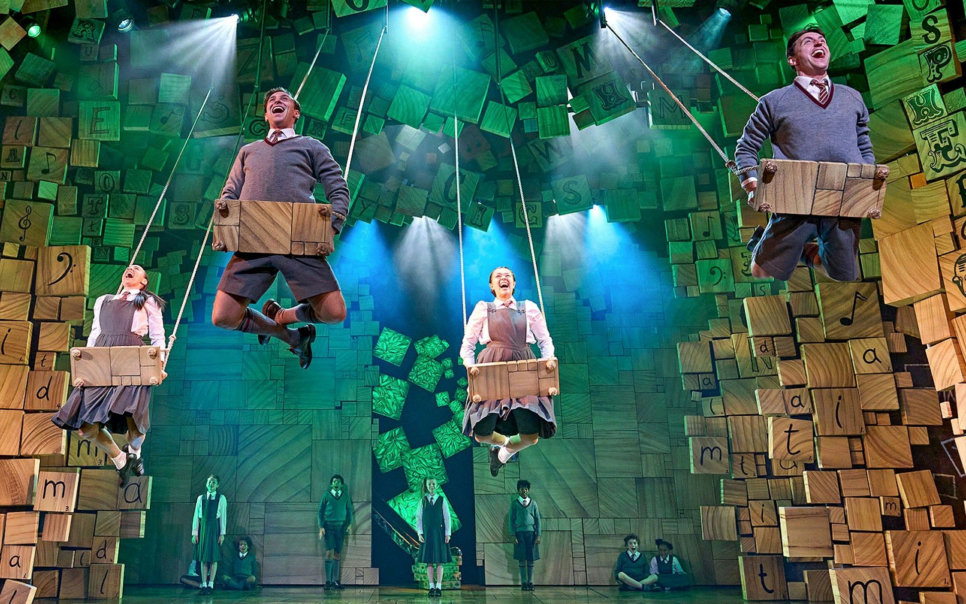 Performers on swings during a scene from Matilda The Musical