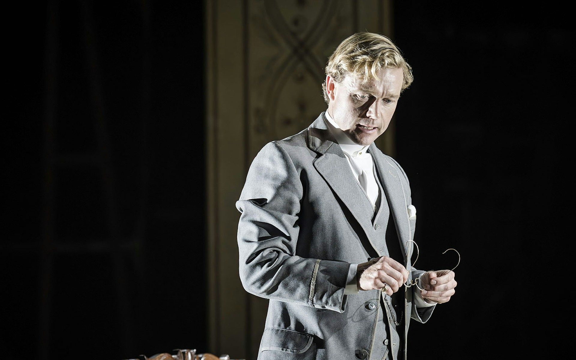 Performer in Grace Pervades West End show holding glasses on stage