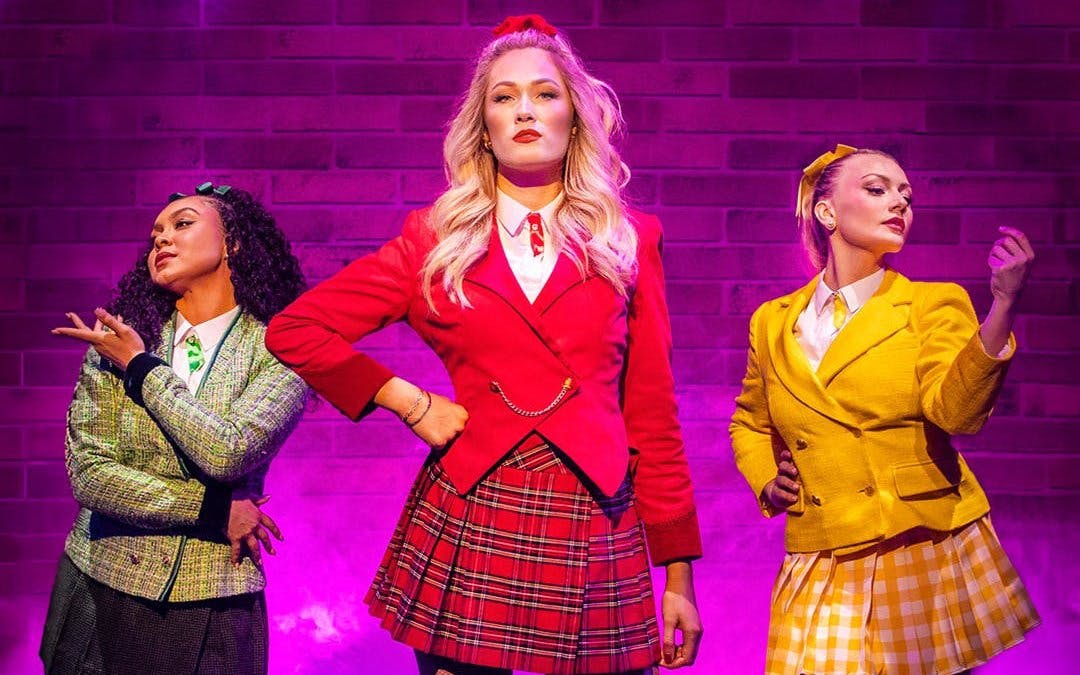 Performers in colorful costumes on stage in Heathers the Musical, West End