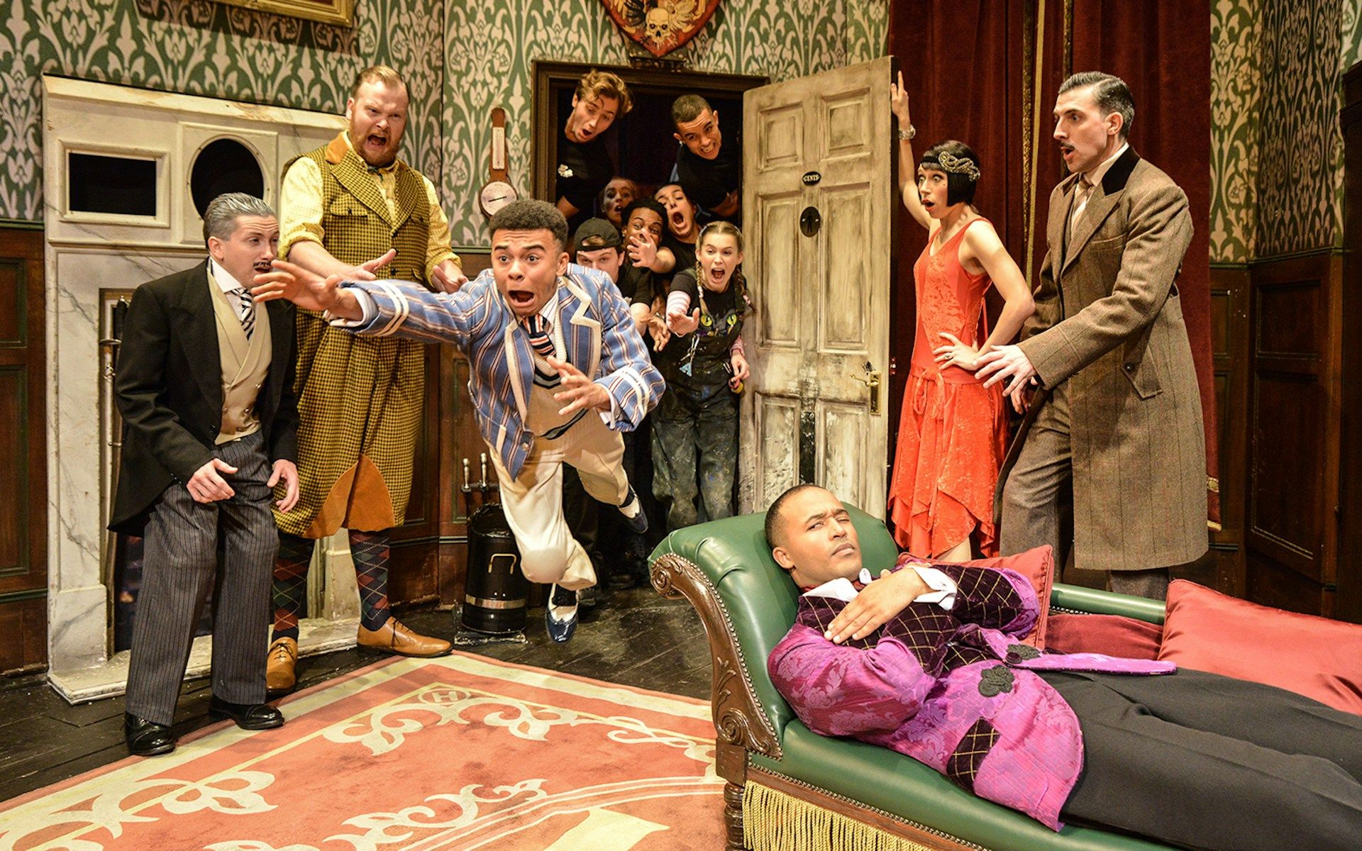 Actors performing a chaotic scene in "The Play That Goes Wrong" on stage