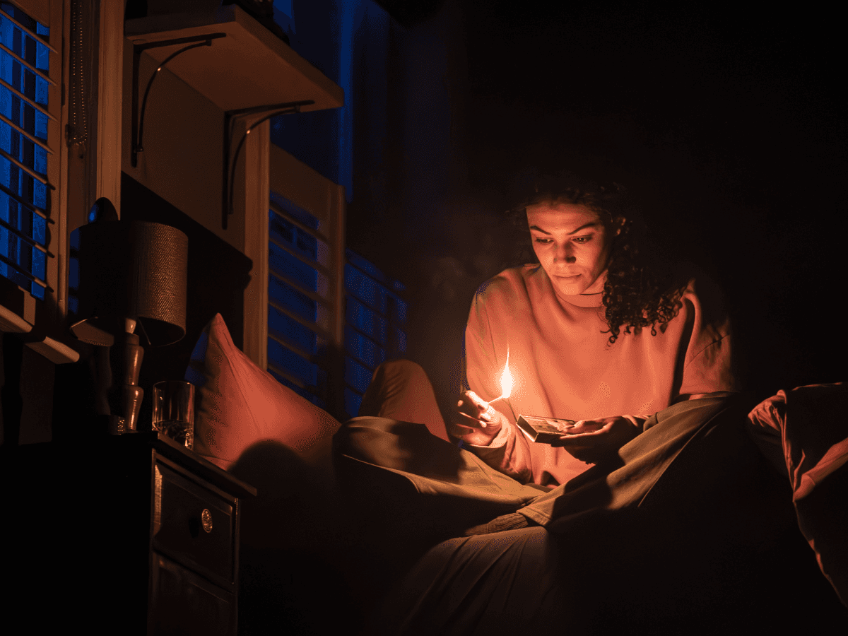 Stage scene from Paranormal Activity in Westend with person holding a lit match