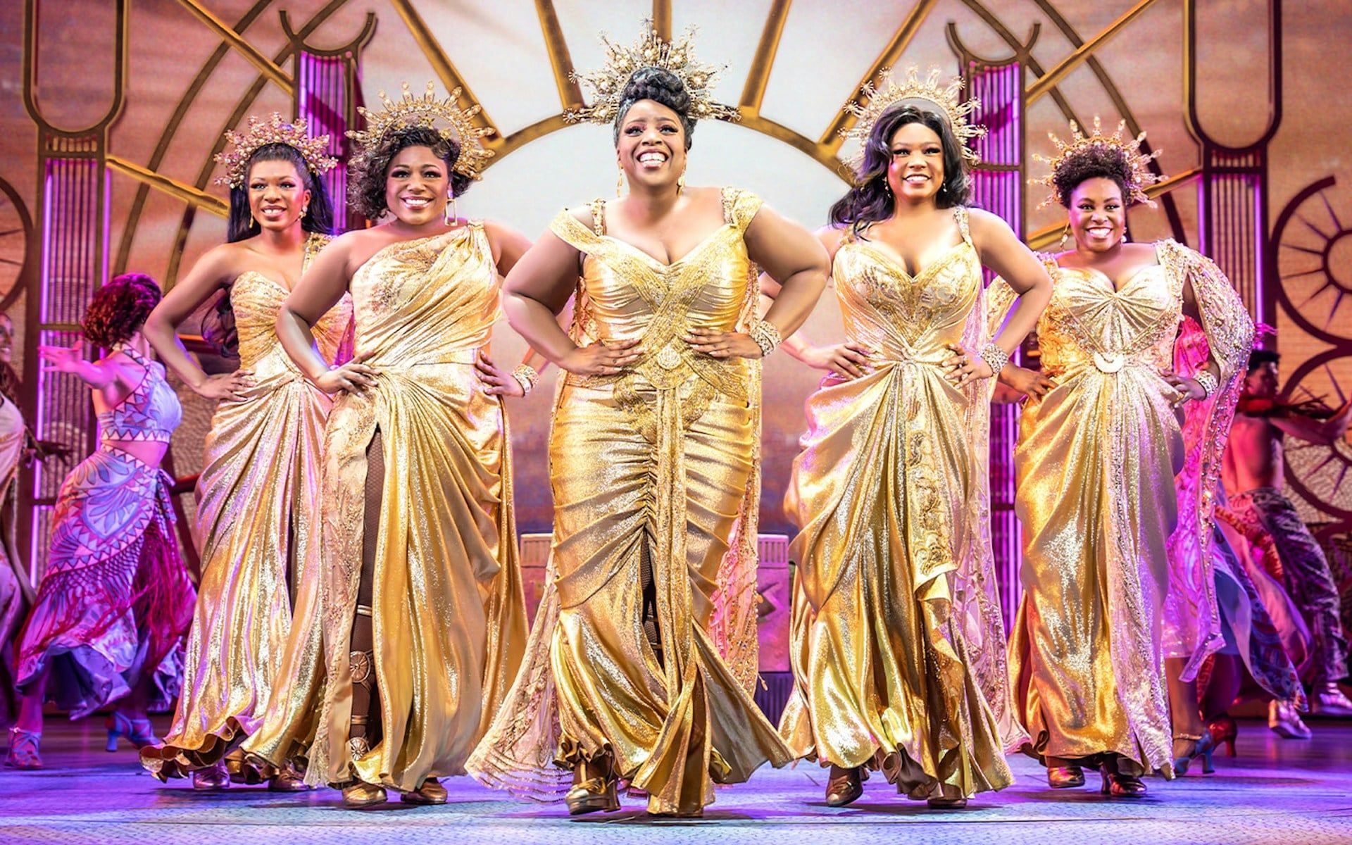 Performers in golden costumes on stage during Disney's Hercules musical