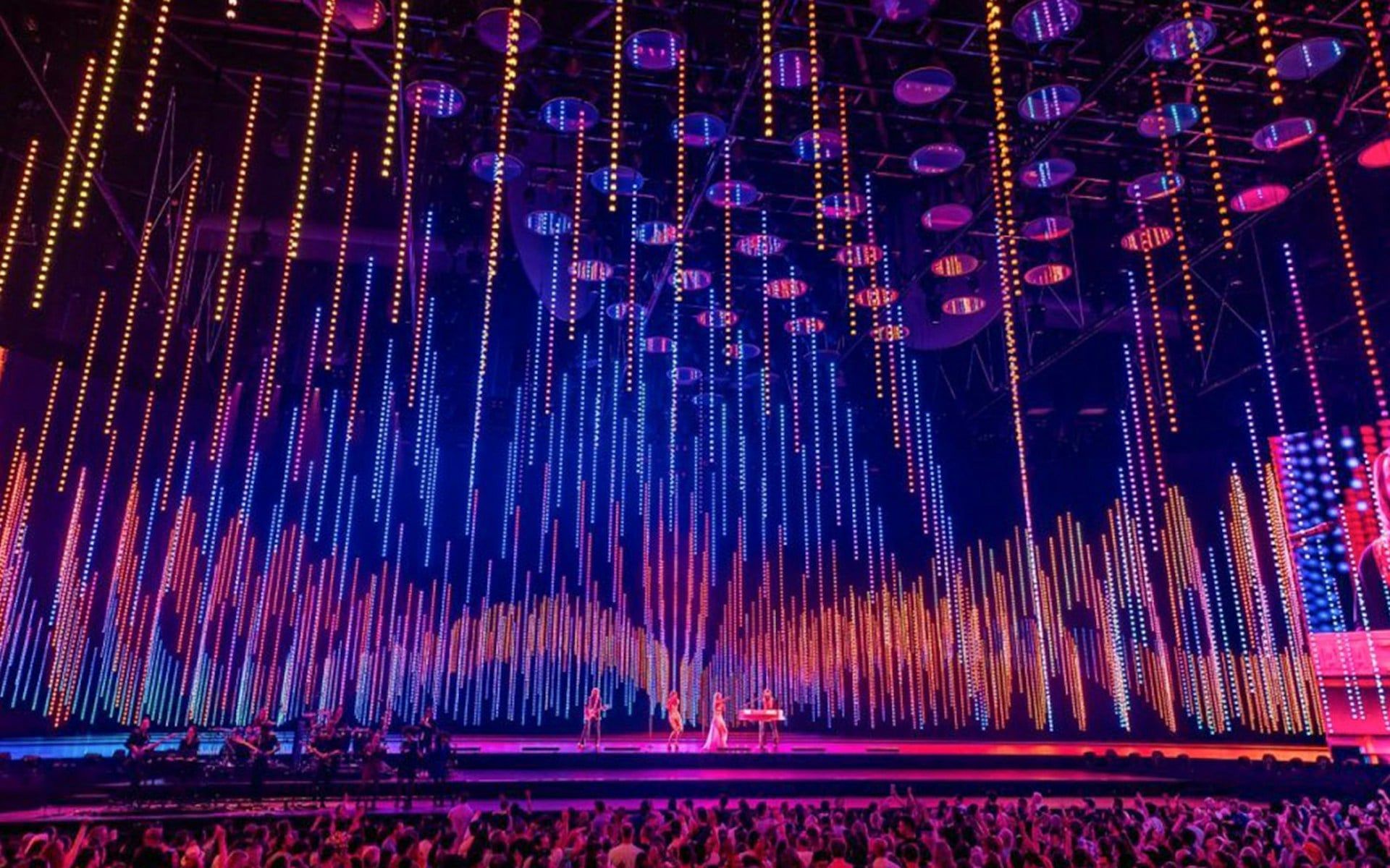 ABBA Voyage concert stage with colorful light display and audience
