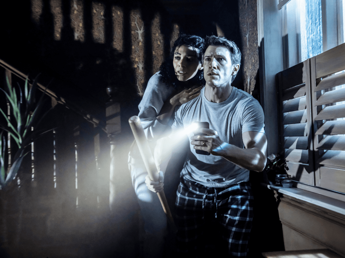 Couple holding flashlight and bat during Paranormal Activity stage performance, Westend