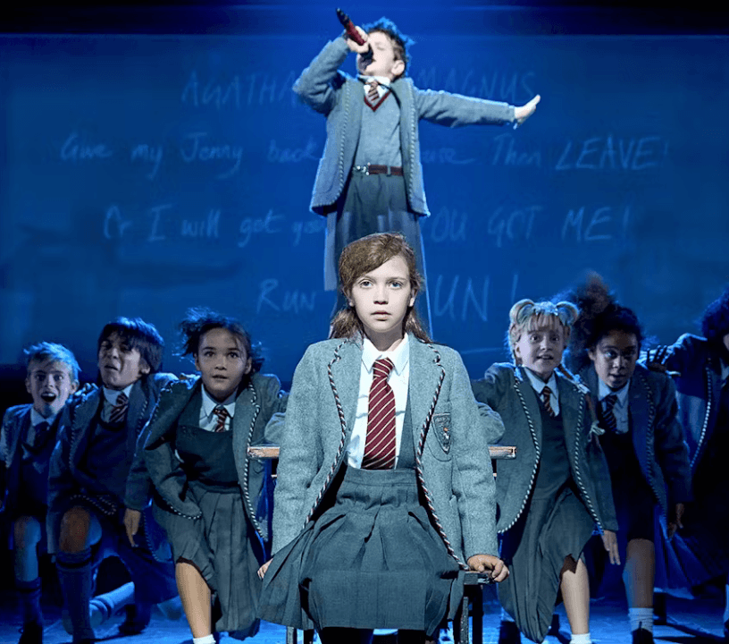 Children performing a scene from Matilda The Musical on stage