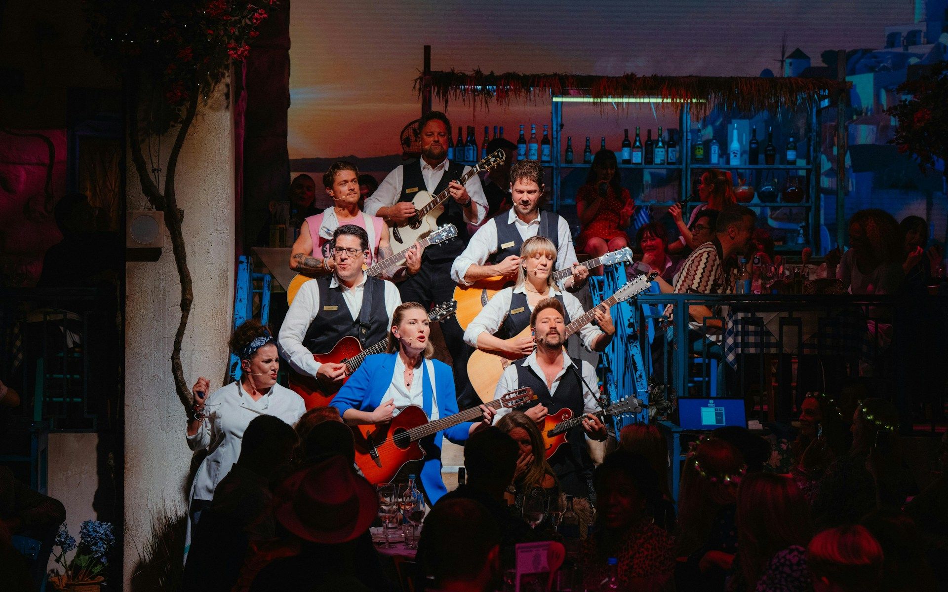 Performers playing guitars during Mamma Mia! The Party show