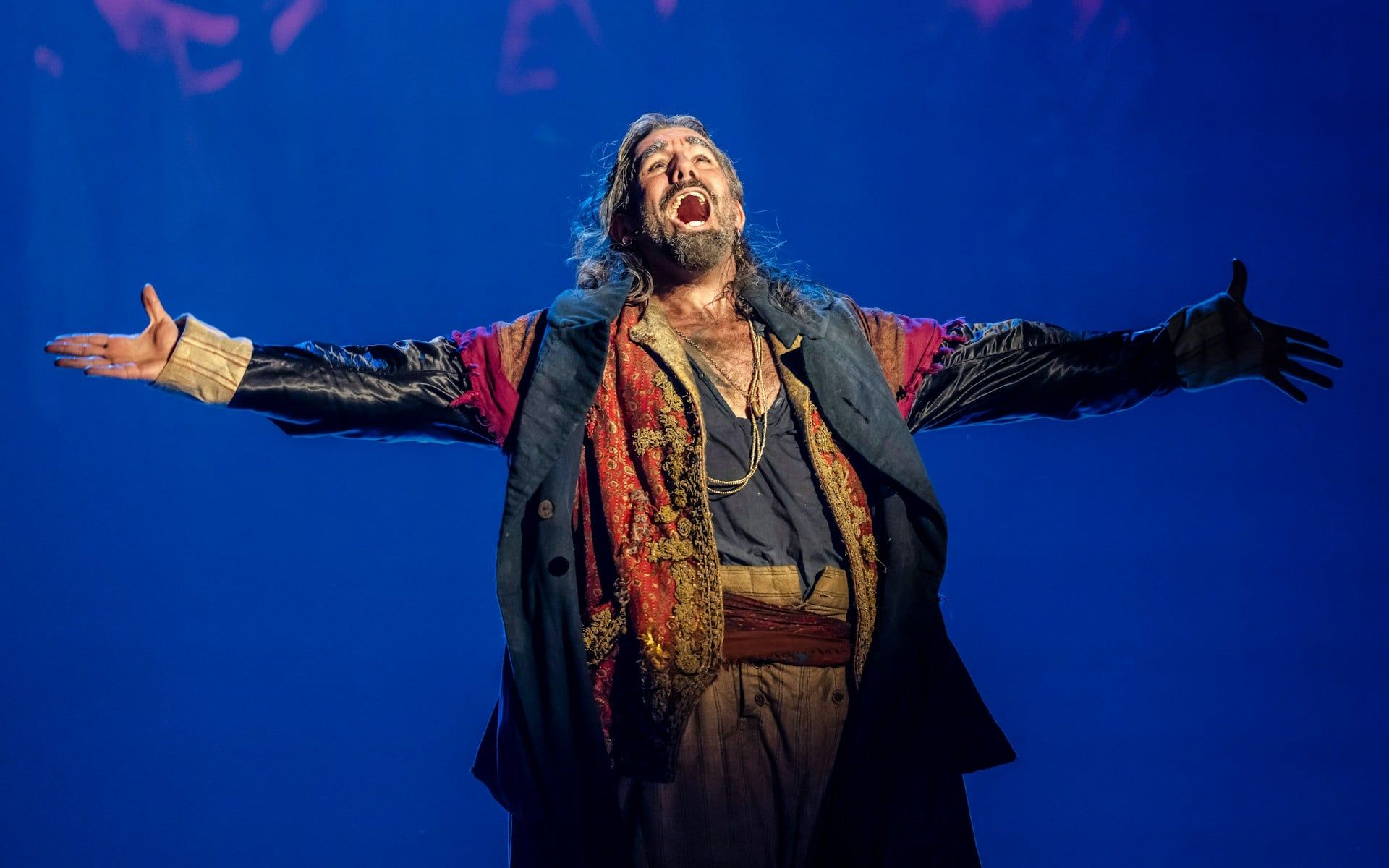 Performer in costume on stage during Oliver production