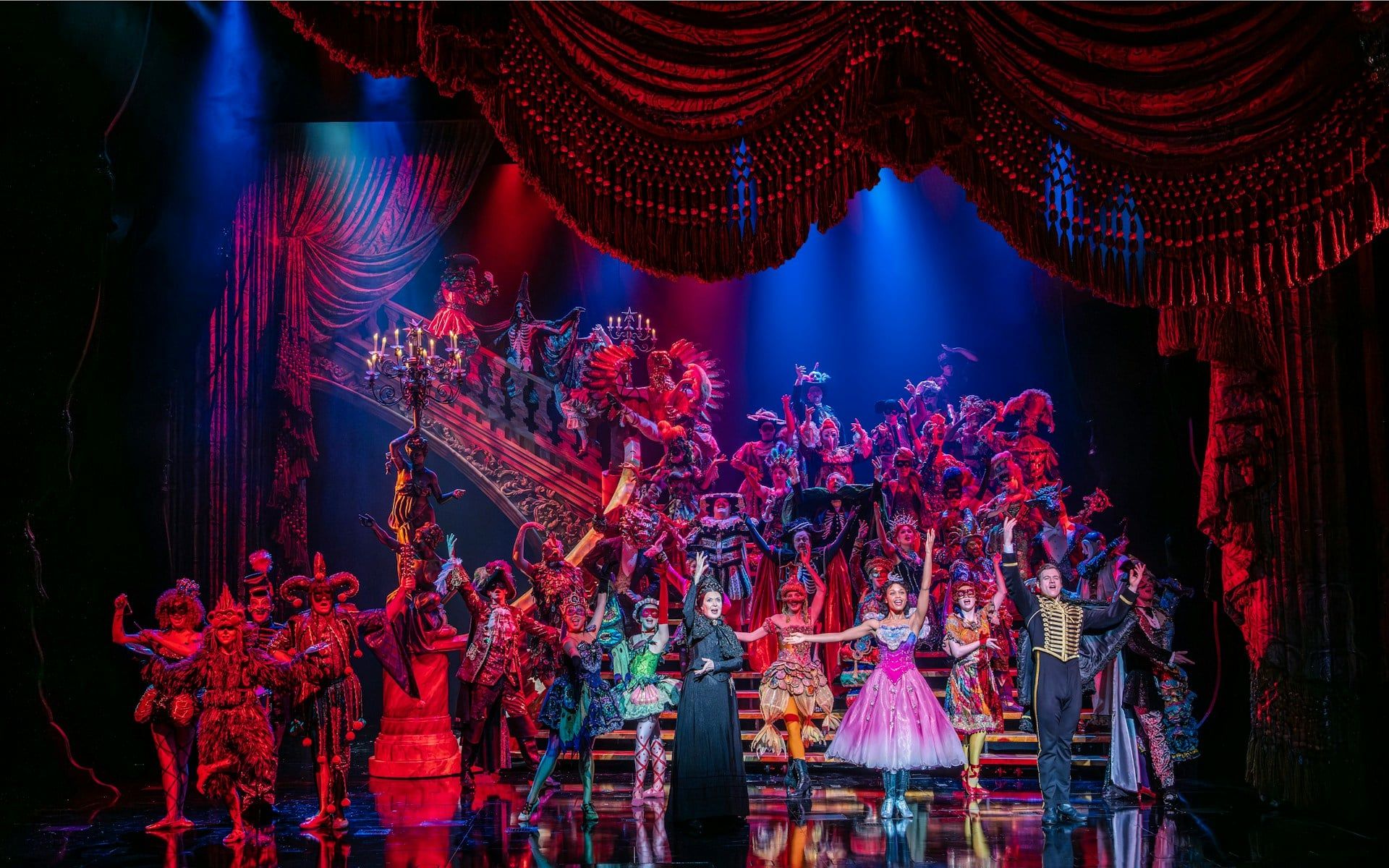 Phantom of the Opera cast performing a vibrant masquerade ball scene on stage — The Phantom of the Opera
