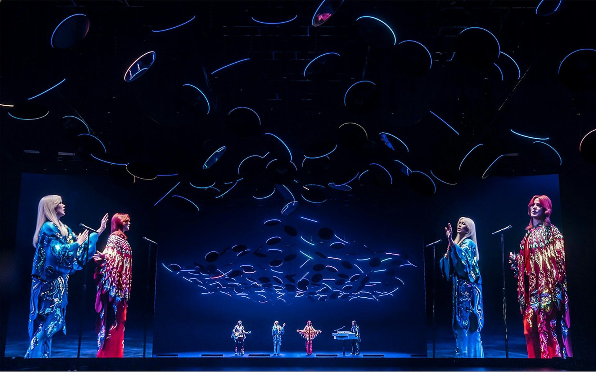 ABBA Voyage concert stage with holographic performers and dynamic lighting effects