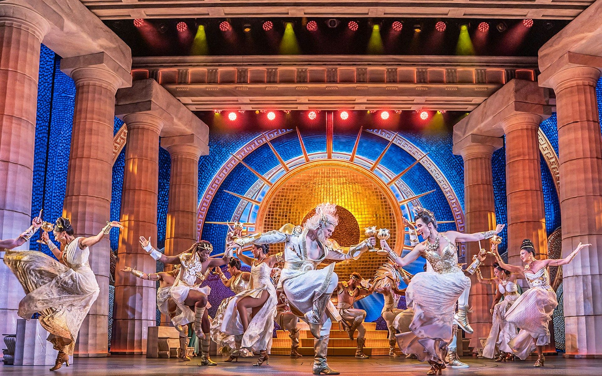 Performers dancing in a vibrant scene from Disney's Hercules stage show
