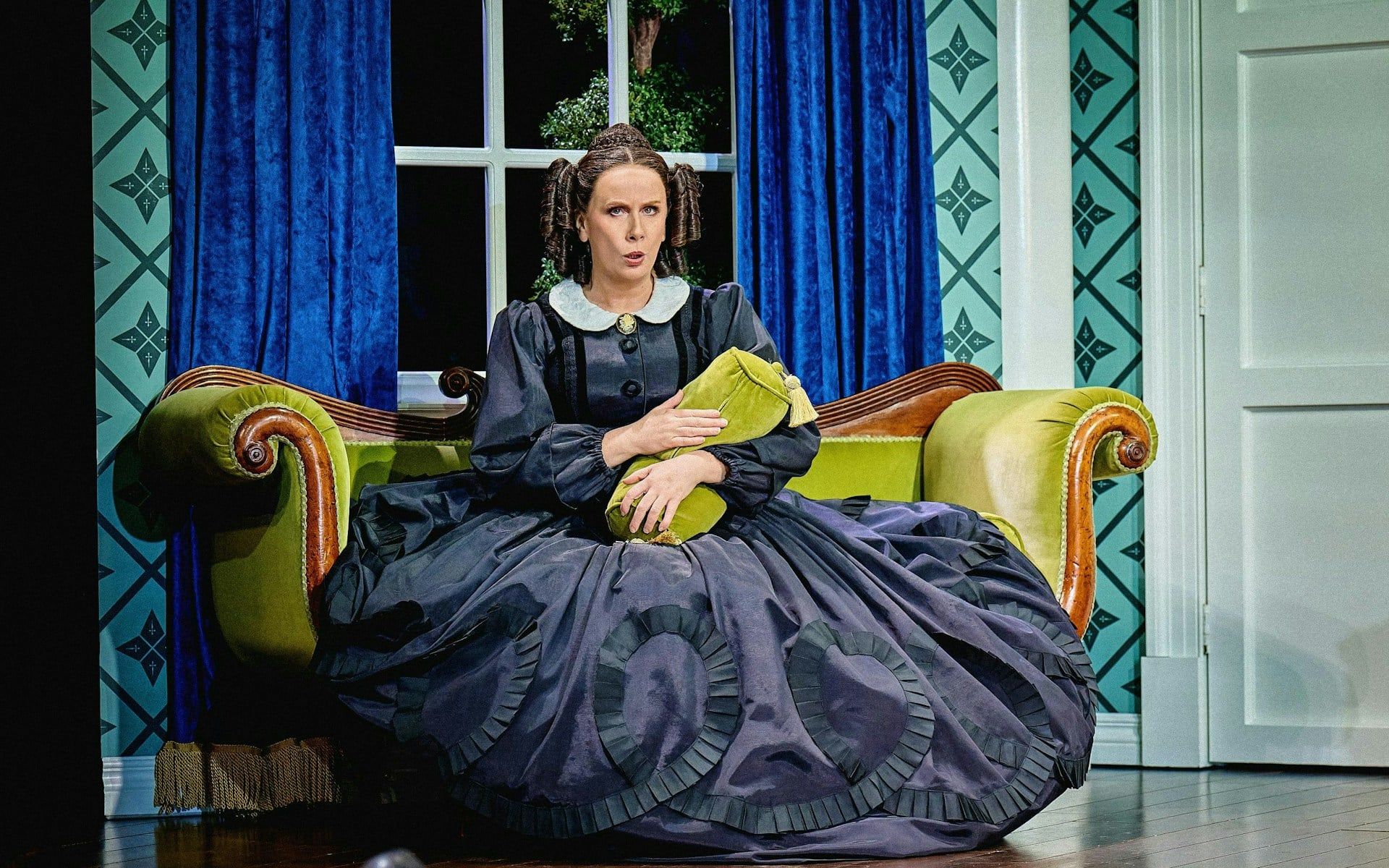 Stage scene from Oh, Mary Westend show with actor in period costume on a vintage sofa