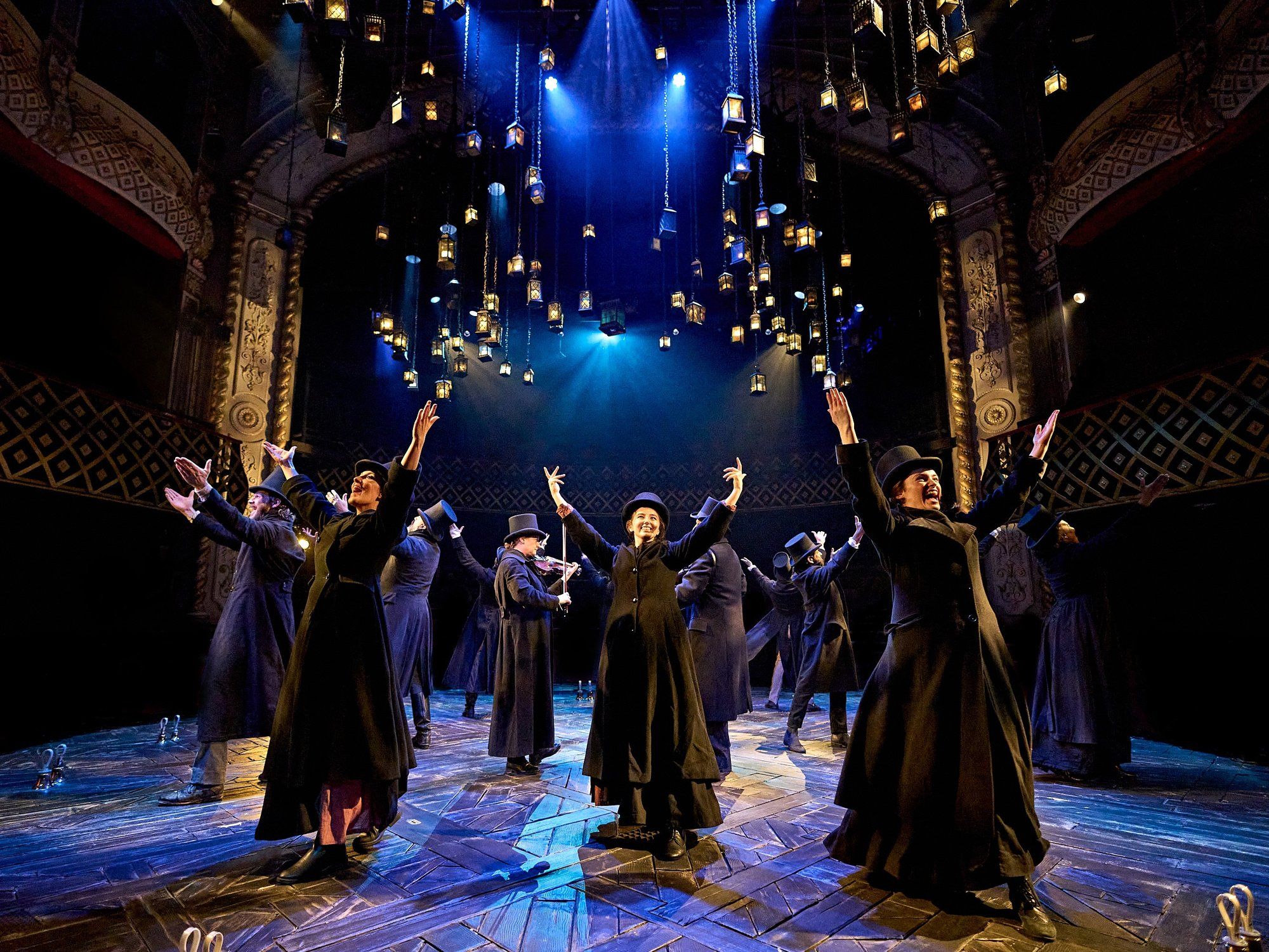 A Christmas Carol at The Old Vic (previous year's production): The company in black coats and top hats beneath the lanterns. Photo: Manuel Harlan