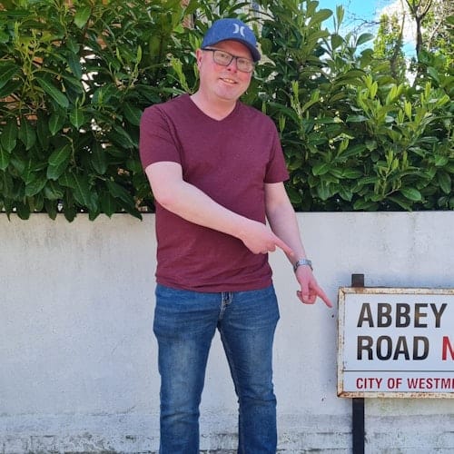 A man standing, pointing to the roadside